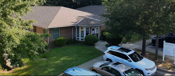 Brick building with bay windows and parked vehicles in front