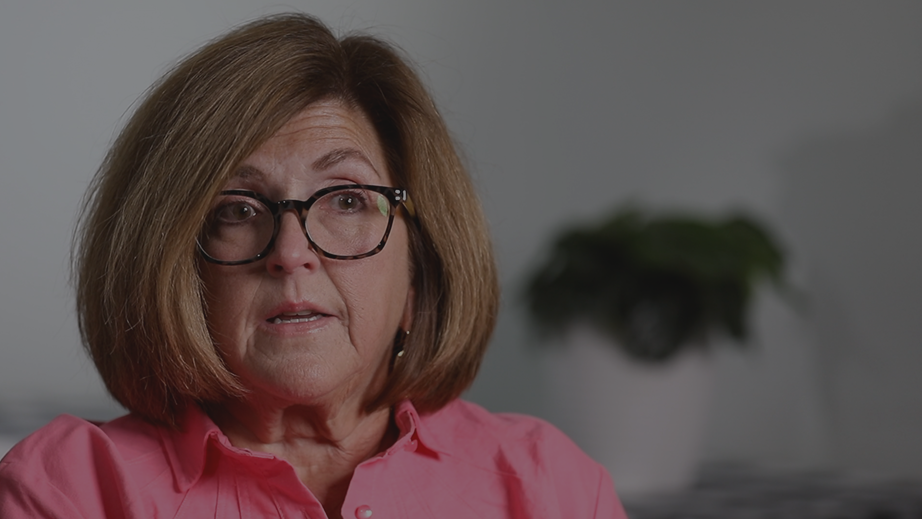 Middle-aged woman with glasses wearing a pink shirt