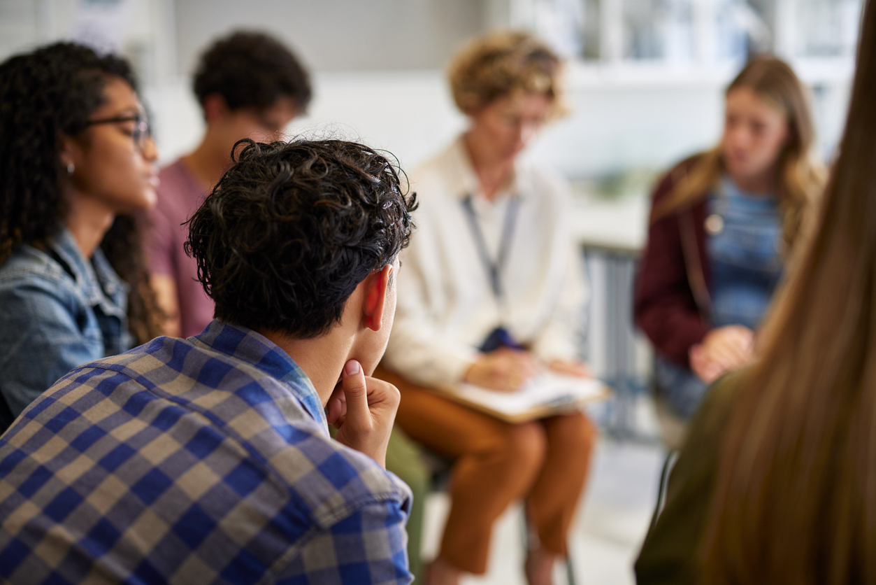 Teenagers and counselor in a group discussion on emotional well-being