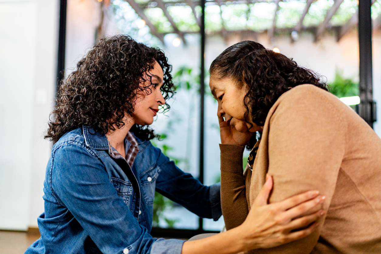 Young woman comforting older woman showing support and care