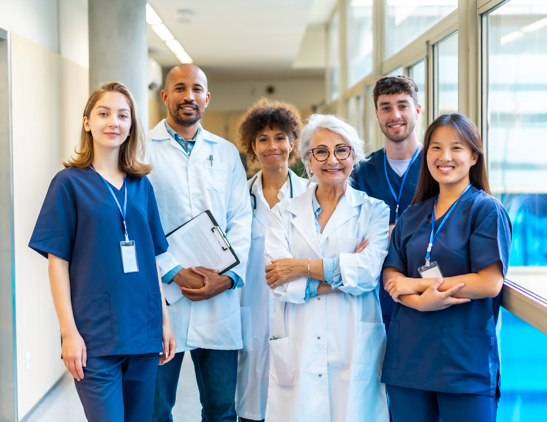 Diverse medical team smiling in hospital corridor