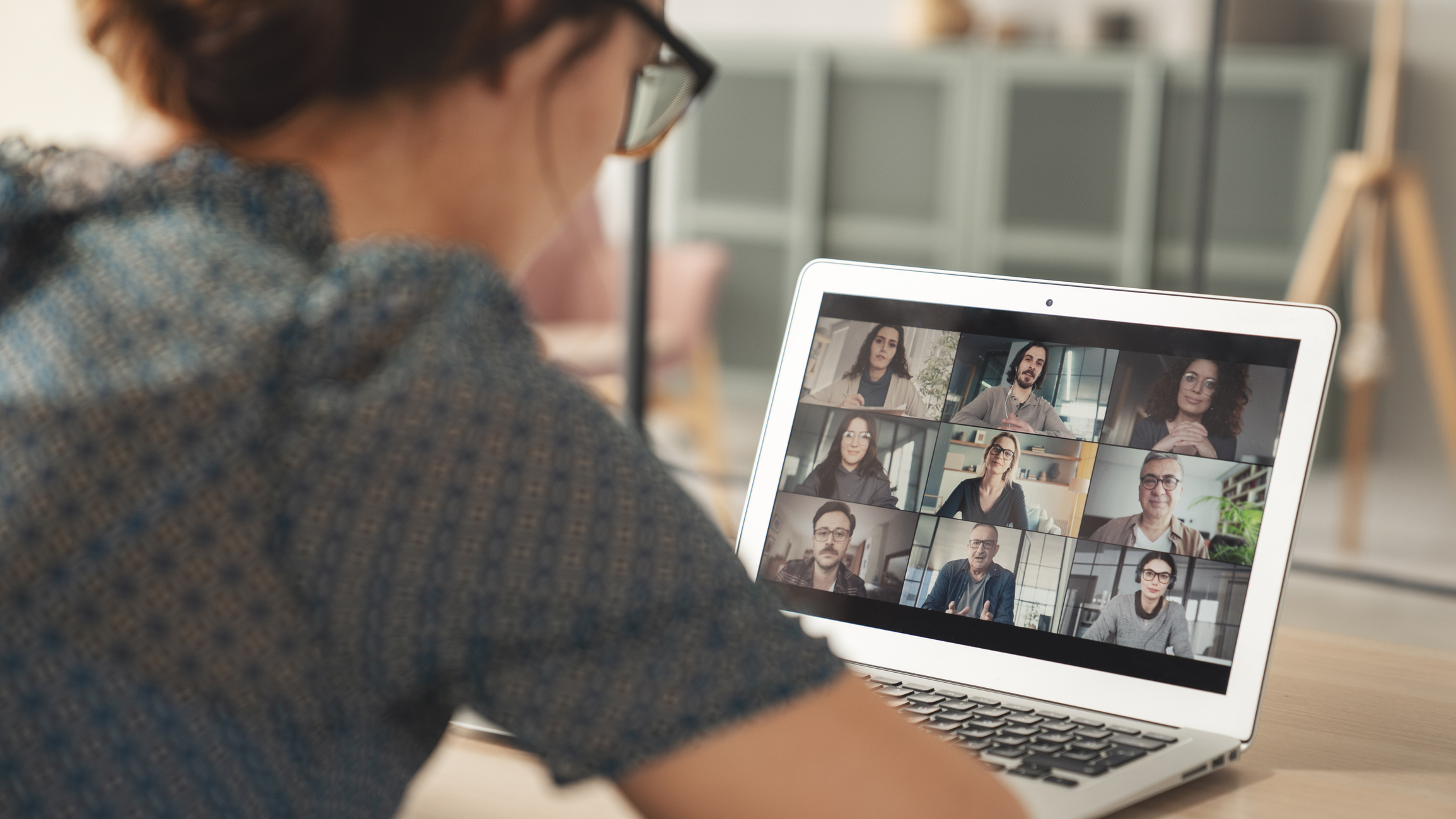 Woman participating in multi-person video conference call on laptop
